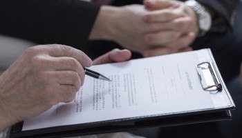 A couple holding hands and reading through a trust and probate document.