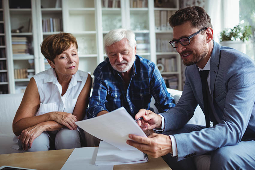 elderly couple reviewing estate planning documents with their advisor