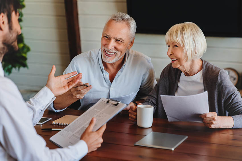 happy older couple discussing estate planning with their attorney