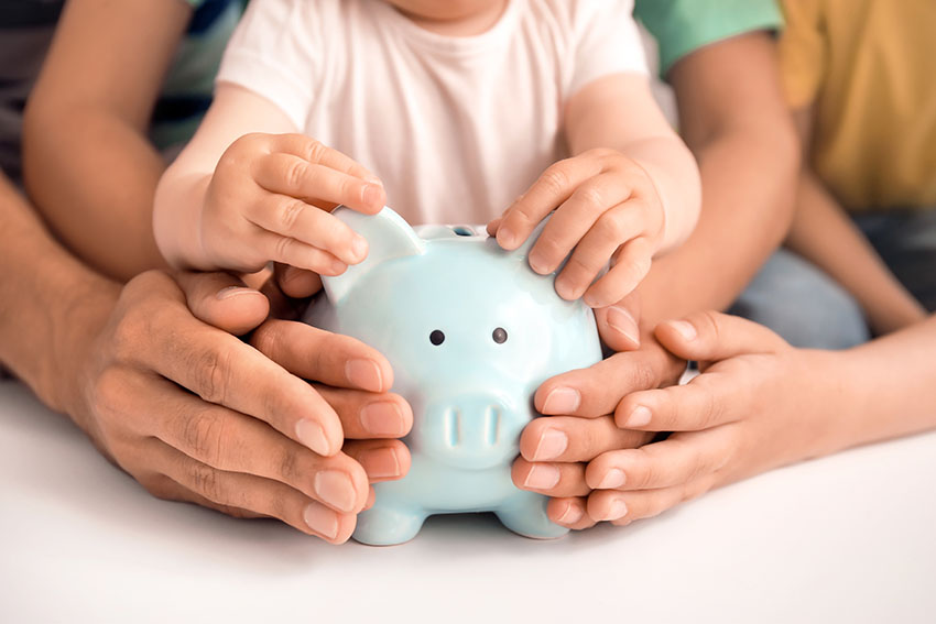 Family of three holding a piggy bank to symbolize family asset protection